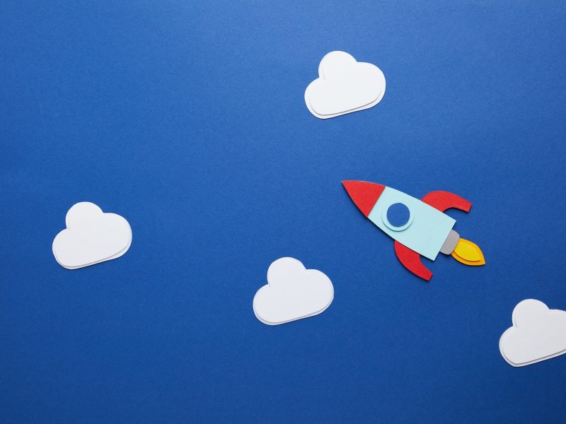 white clouds and rocket on blue background
